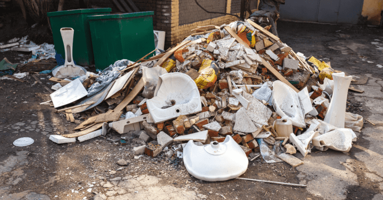 Construction site cleanup with a pile of debris and waste materials.