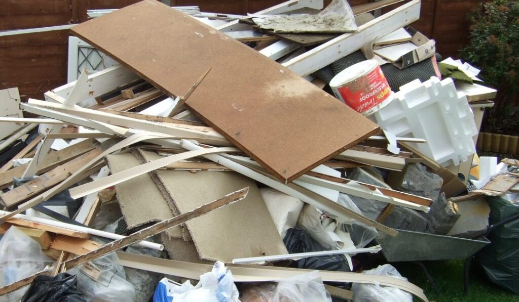 Image of a construction site with piles of builders' waste, including bricks and wood.